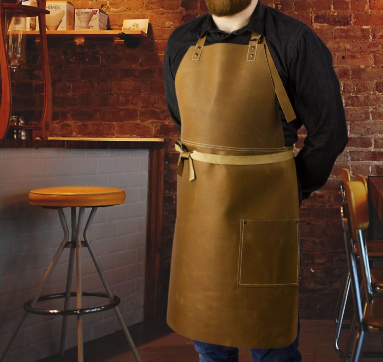 Long leather bib apron worn by model in bar