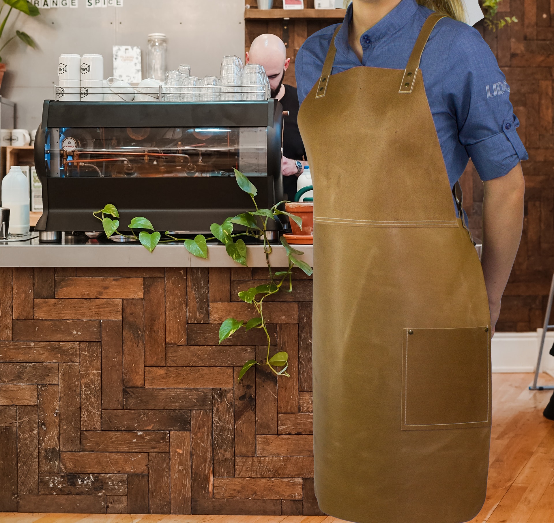 Cross back bib apron on model in cafe